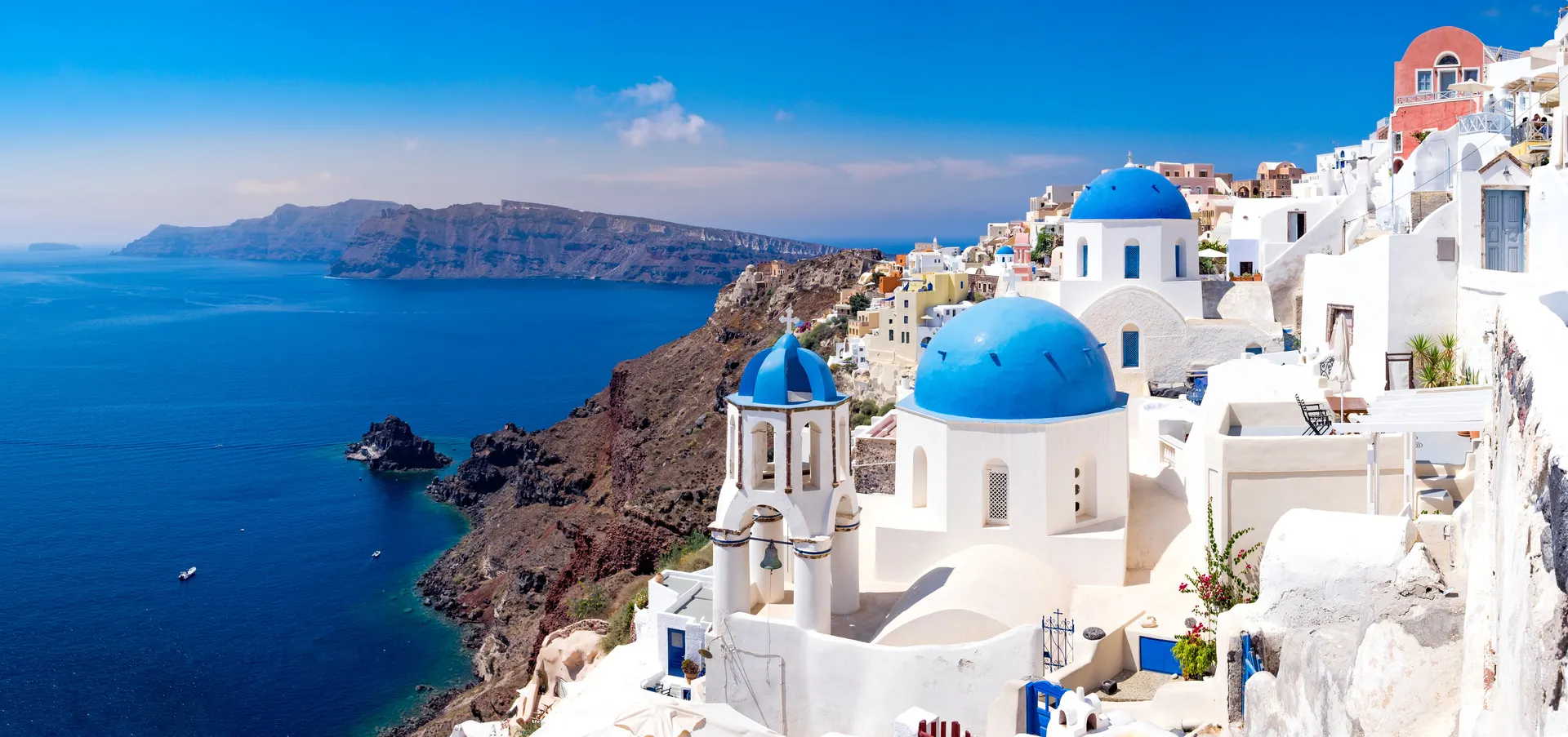 Panoramisch uitzicht op mooie witte huizen en blauwe koepels in Oia, Santorini, Griekenland