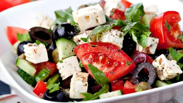 Een Griekse salade met tomaat, olijven, komkommer en feta. 