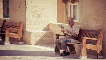 Oude man leest de krant op straat in Valletta