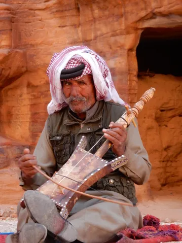 Man met muziekinstrument in Petra, Jordanië