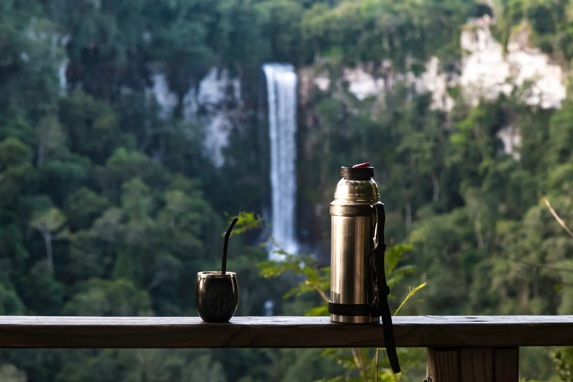 mate herb gourd and canteen in fron of Salto Encantado waterfall in Missiones, Argentina