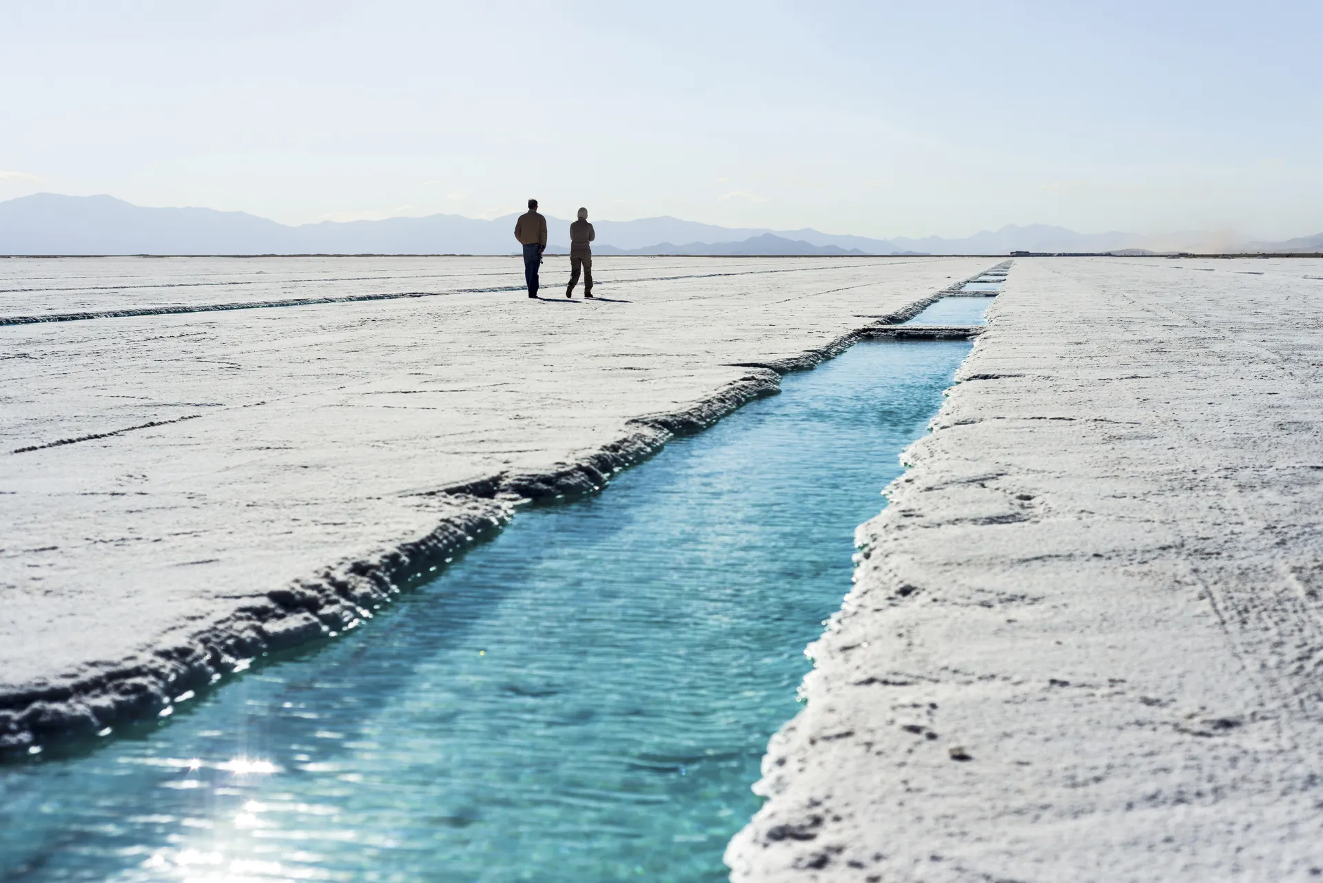 People walking near salt water pool on the Salinas Grandes salt flats in Jujuy province, northern Argentinië