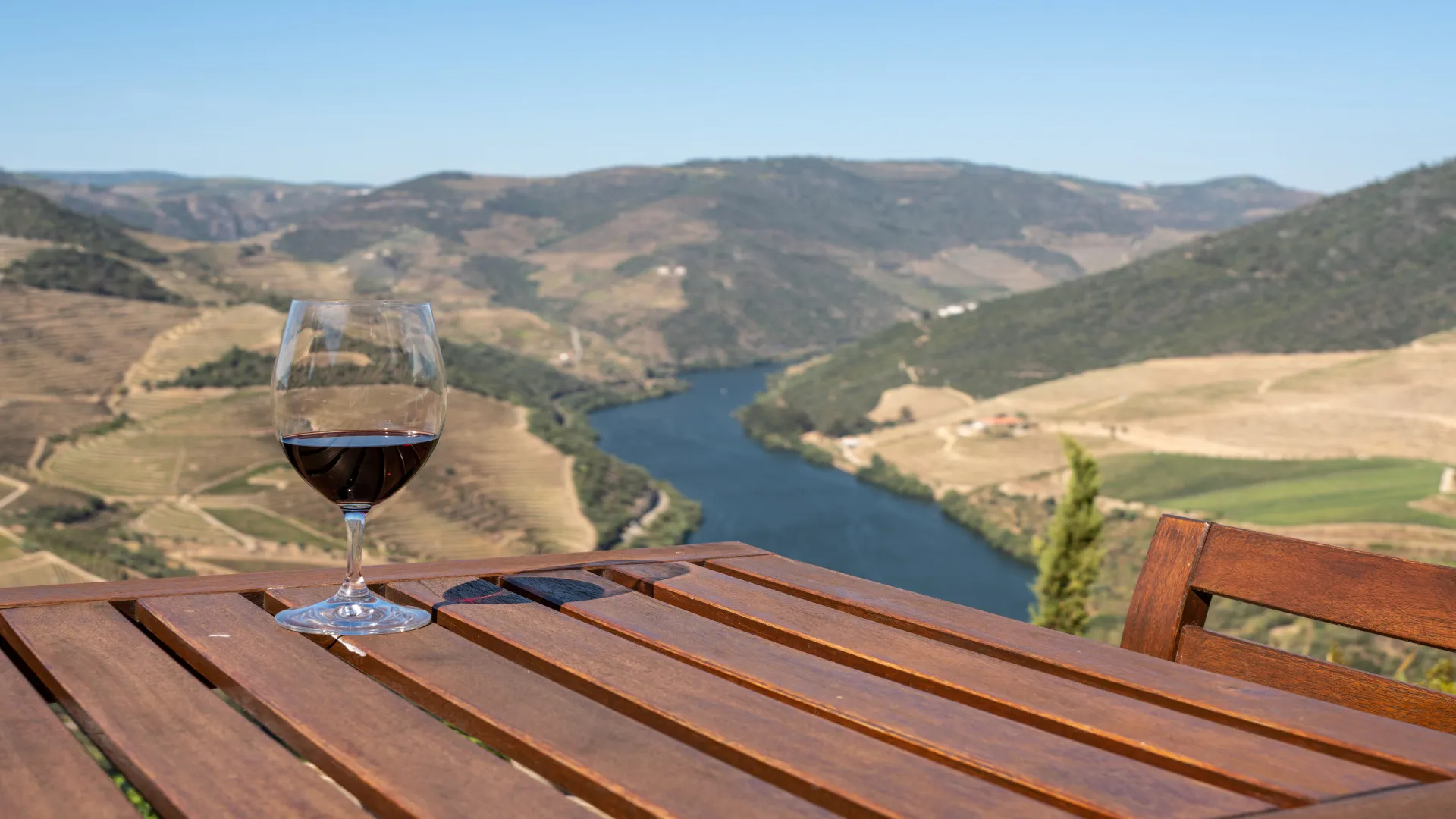 Glas rode Port op tafel met uitzicht op de Douro vallei, Portugal