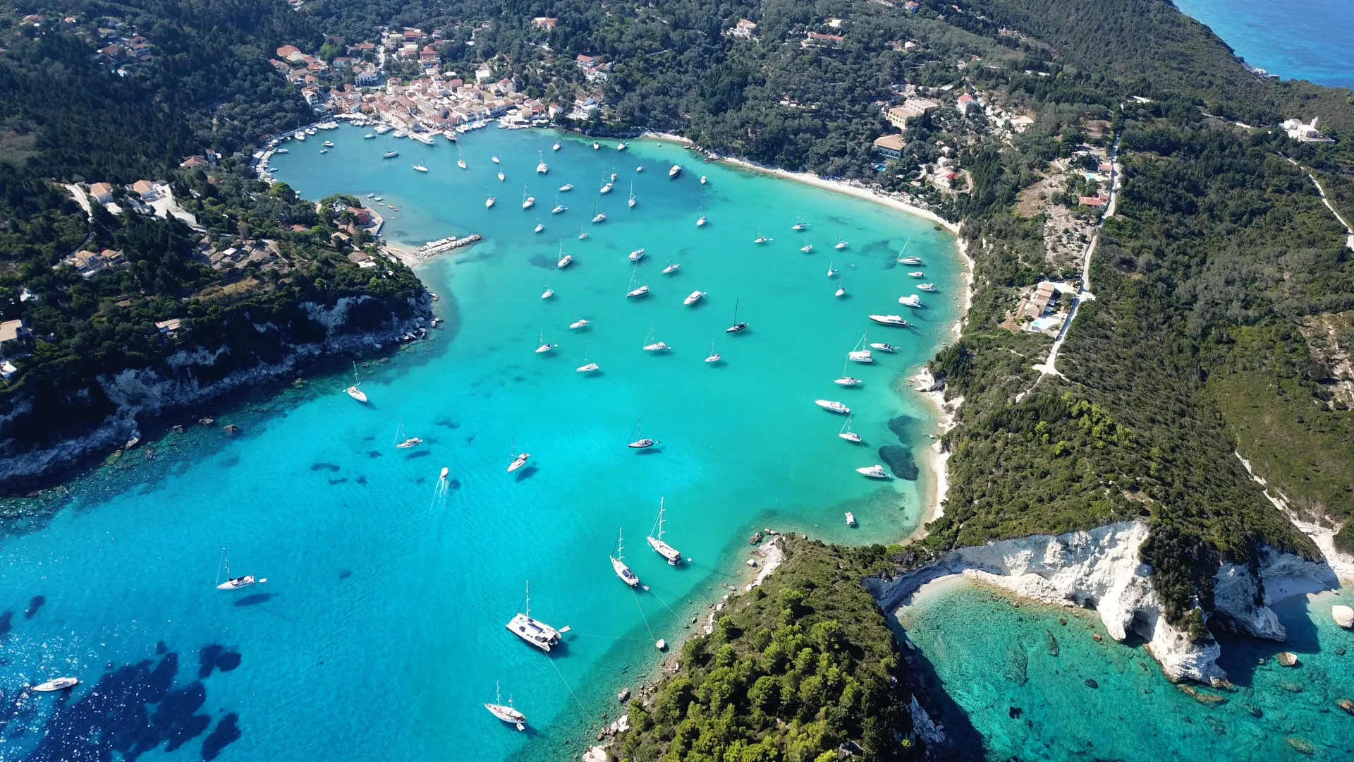 Luchtfoto van kleine haven en vissersdorpje Lakka met zeilboten in de baai, Paxos eiland, Griekenland