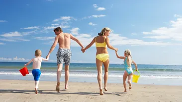 Ouders met kinderen op het strand