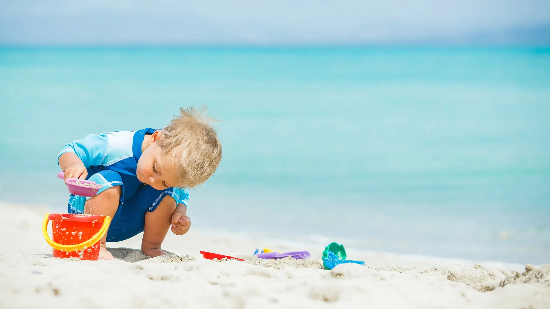 jongetje speelt op het strand