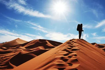 Man op duin in woestijn Marokko