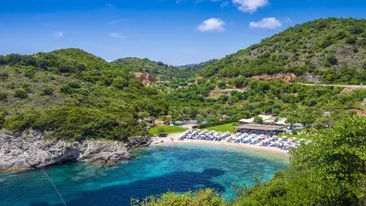 Strand omringd door blauw water en groene bomen op de heuvels, Albatros, Epirus, Griekenland