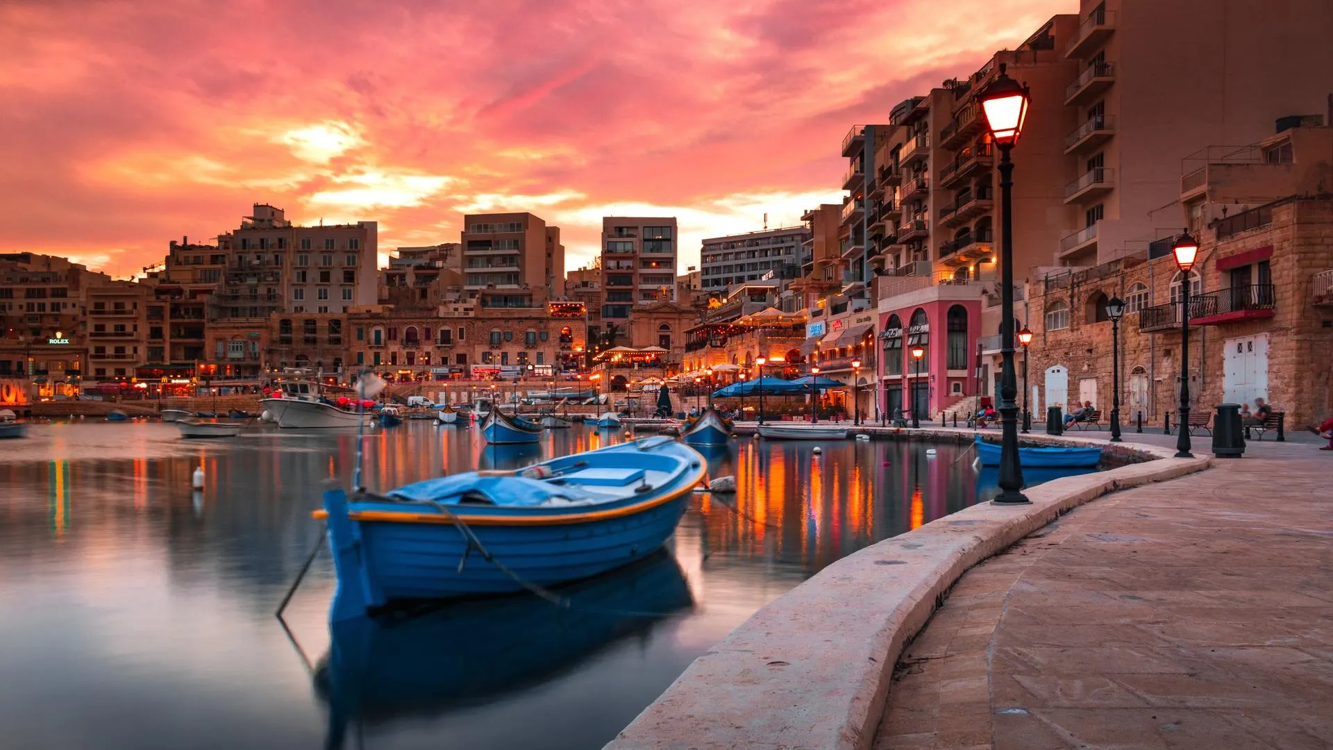 Malta ondergaande zon haventje met boot op voorgrond