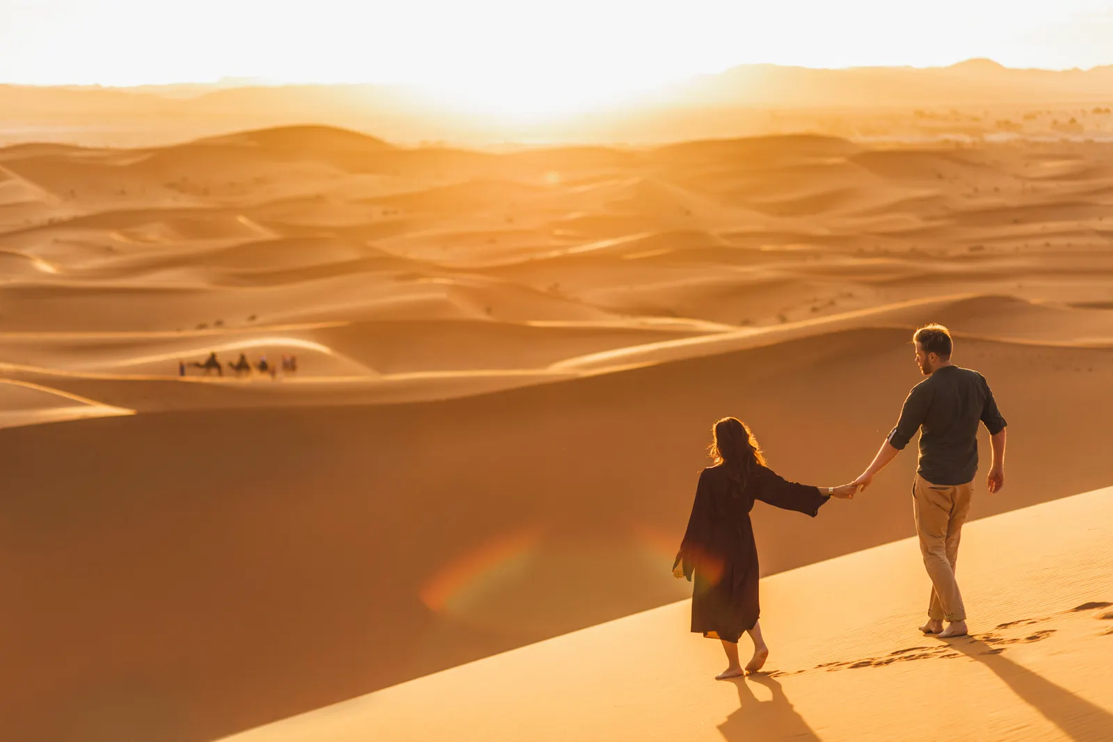 &Olives Morocco Paar wandelen in de Sahara woestijn bij zonsondergang.