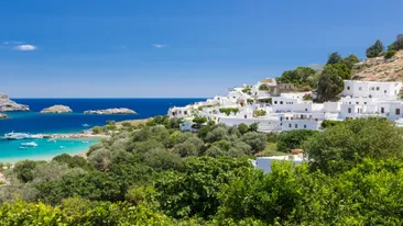 Lindos, Rhodos, Griekenland, heuvel met witte huisjes en groene bomen