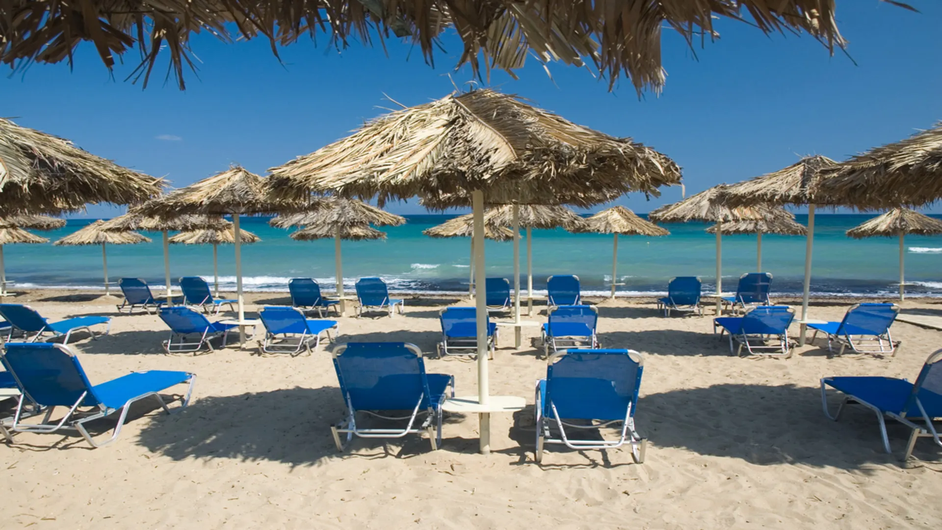 Ligbedden onder parasols op het strand