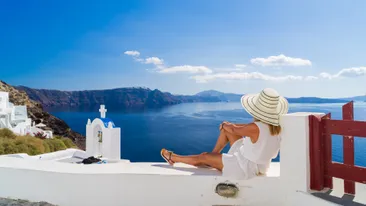 Dame met hoed die geniet van het uitzicht vanaf het Griekse eiland Santorini