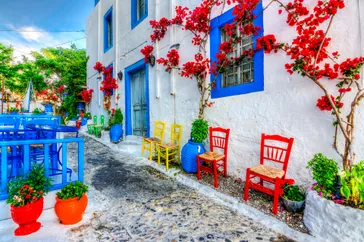 Straatje Kos met kleurrijke stoeltjes, potten en bloemen, Kos, Griekenland