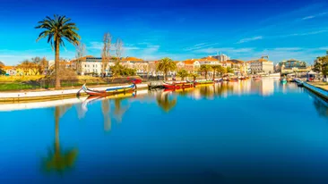 Uitzicht op het stadje Aveiro met op voorgrond rivier met kleurrijke bootjes, Aveiro, Portugal